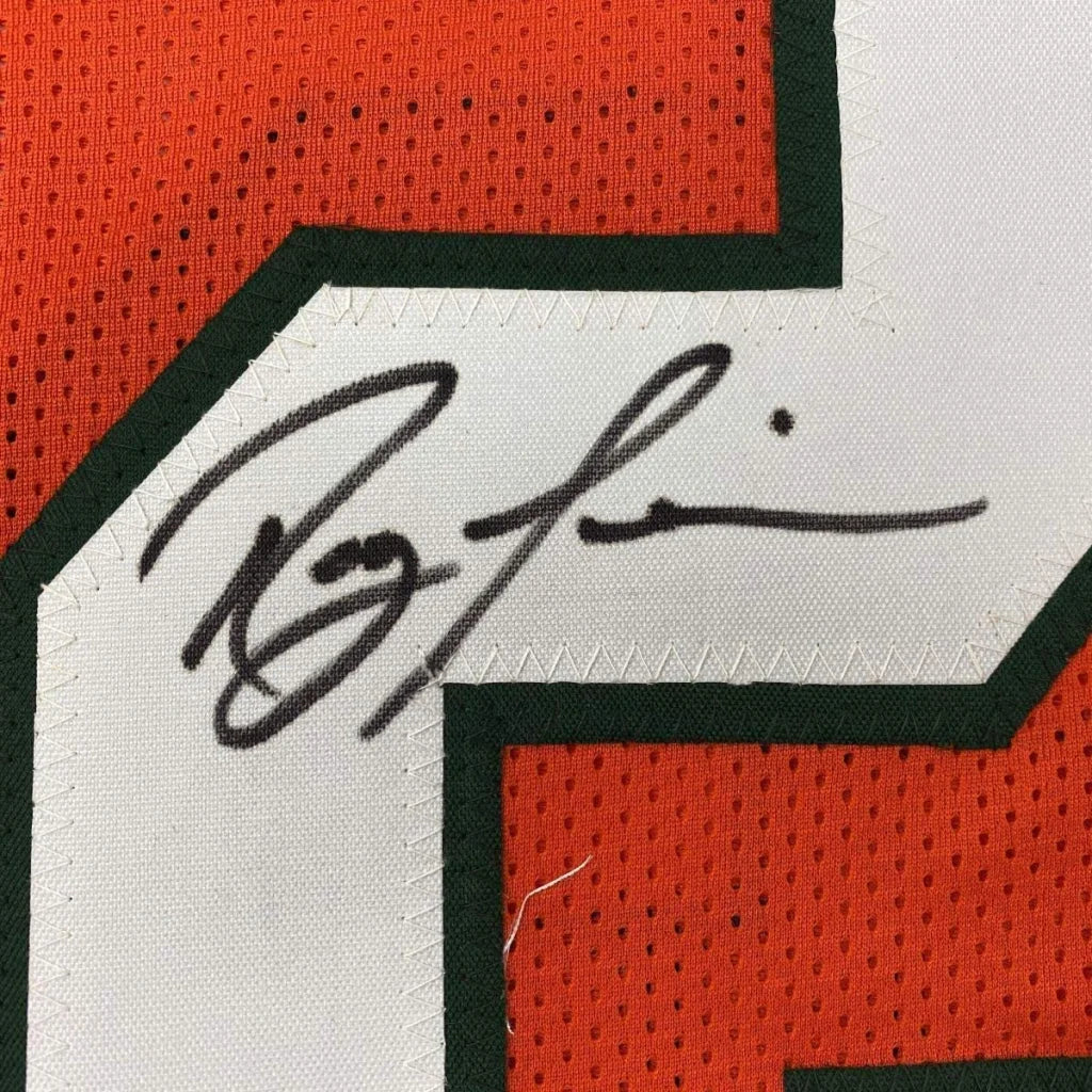 A black ink signature on a white mesh Miami orange college football jersey with orange and green accents
