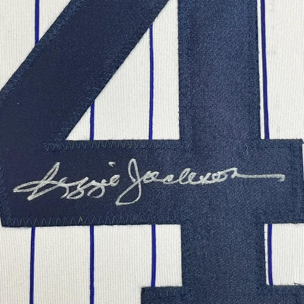 Framed autographed Reggie Jackson New York pinstripe baseball jersey with embroidered navy blue number 4 and white signature