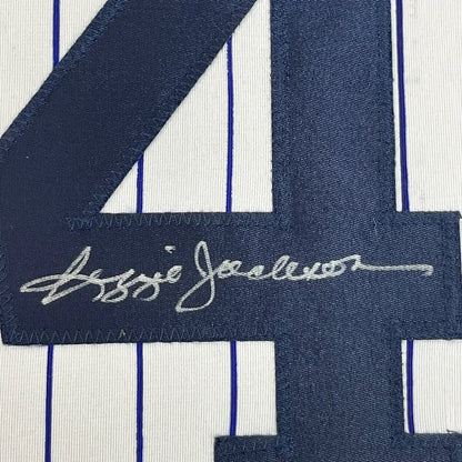 Framed autographed Reggie Jackson New York pinstripe baseball jersey with embroidered navy blue number 4 and white signature