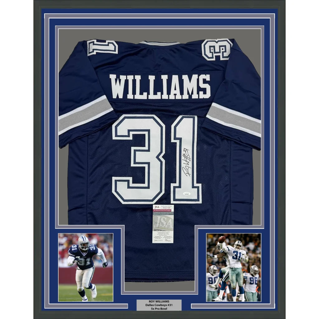 Framed autographed navy blue Dallas Cowboys football jersey of Roy Williams size 35x39 with JSA COA displayed