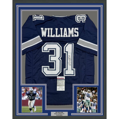Framed autographed navy blue Dallas Cowboys football jersey of Roy Williams size 35x39 with JSA COA displayed