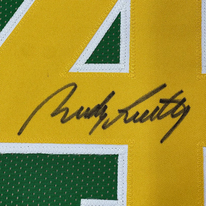Autographed yellow and green Notre Dame Rudy Ruettiger jersey in a professionally framed display