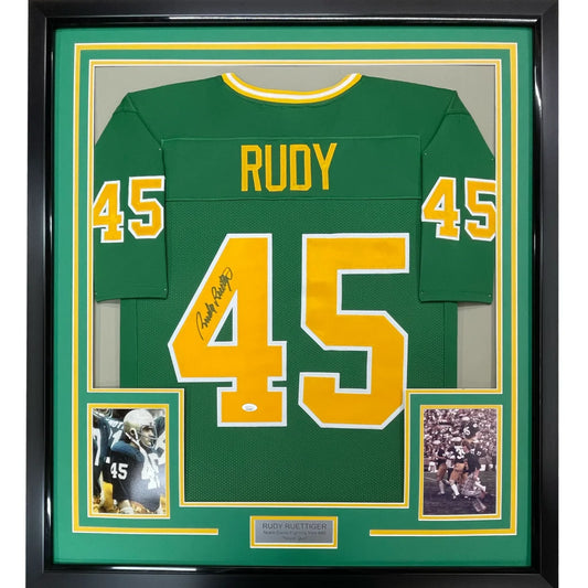 Framed green RUDY football jersey with autograph and photos in a museum display