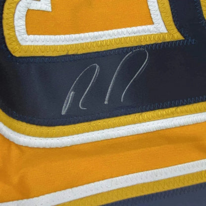 A navy blue and gold framed hockey jersey with a white stitched signature signed by Ryan Johansen