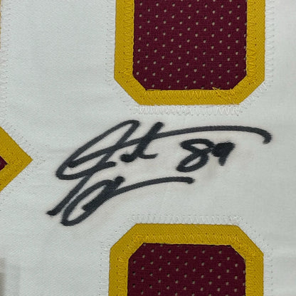 Black ink signature on white fabric washington burgundy football jersey with maroon and yellow stitched patches