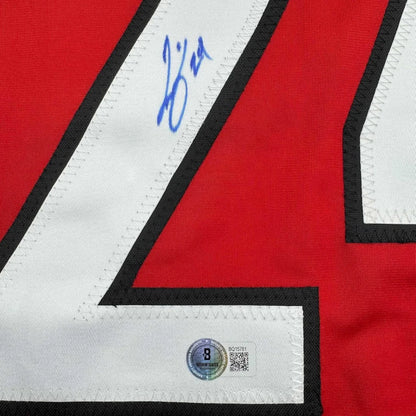 Red sports jersey with white number and blue autograph, professionally framed for man cave