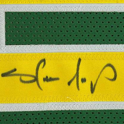 Green and yellow Shawn Kemp SuperSonics jersey with black autograph in a frame