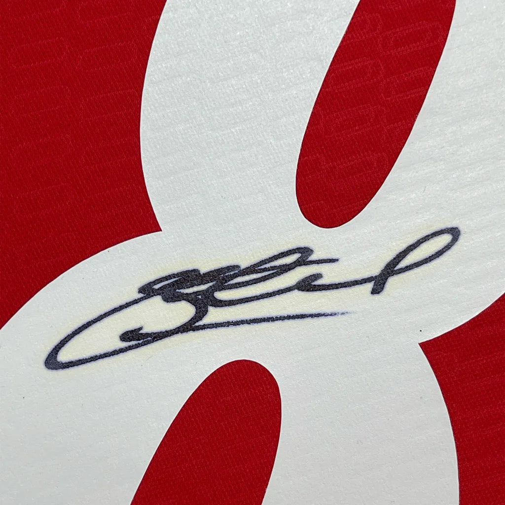 Black ink Steven Gerrard signature on white textured surface with red elements, framed Liverpool jersey Beckett COA