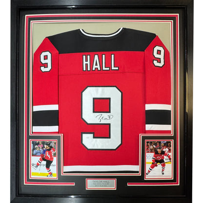 Professionally framed Taylor Hall red hockey jersey with autographed player cards