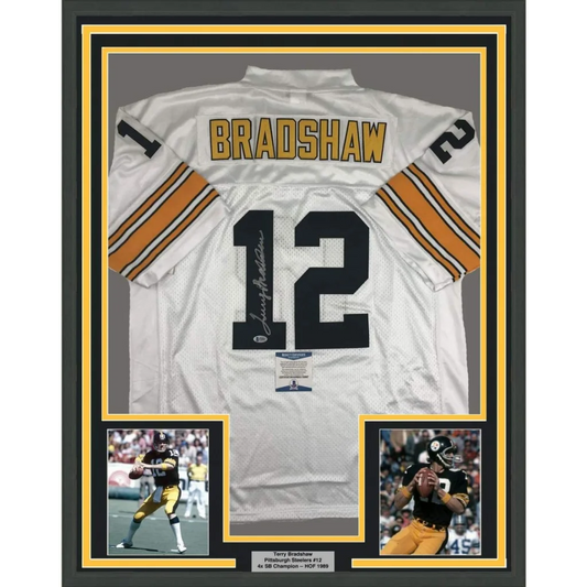Back side of a framed autographed white pittsburgh steelers football jersey with black and gold bradshaw 12 lettering