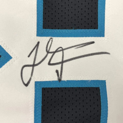 Black ink signature on a white Carolina black football jersey with blue and black mesh panels framed 35x39 inches