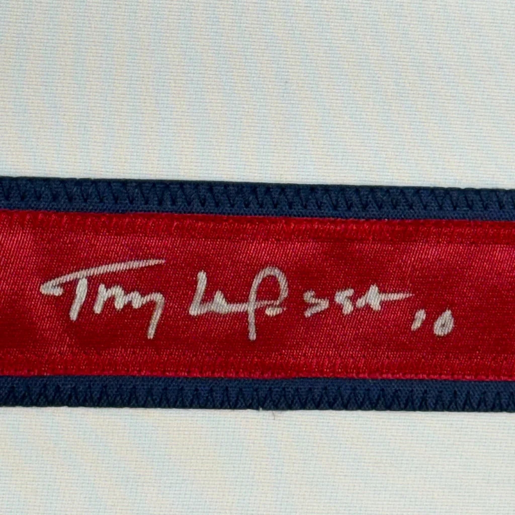 Red and navy blue striped ribbon with a white handwritten signature on Tony La Russa Jersey