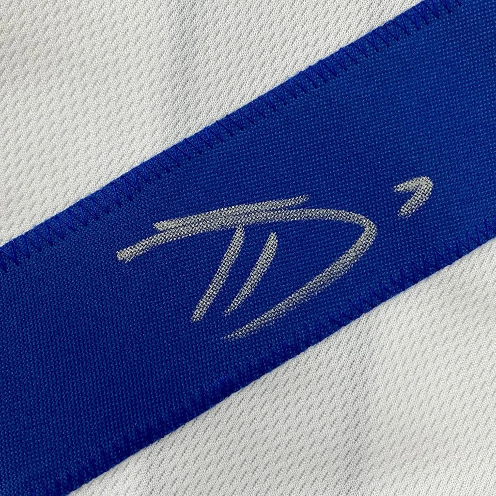 White and blue athletic fabric with silver embroidered logo on professionally framed Dallas Cowboys jersey