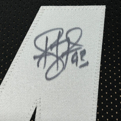 White fabric tag with stitched black ink Troy Polamalu signature on black mesh