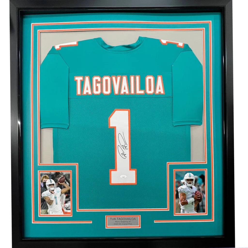 Framed autographed Tua Tagovailoa Miami Dolphins jersey with photos on display
