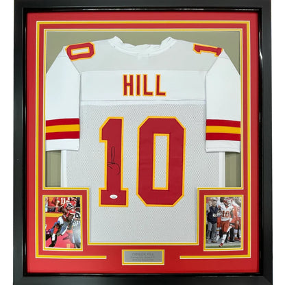 Back side of a framed autographed white Kansas City Chiefs football jersey with red yellow accents signed by Tyreek Hill