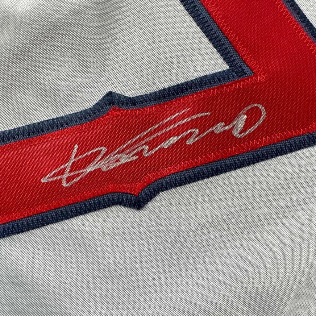 Autographed baseball jersey with red trim in a framed display ready for your wall