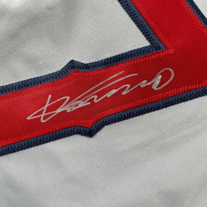 Autographed baseball jersey with red trim in a framed display ready for your wall