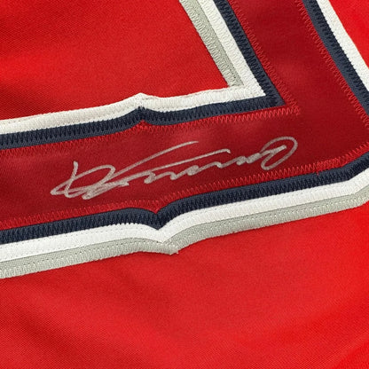 Autographed red baseball jersey with striped trim and embroidered signature display