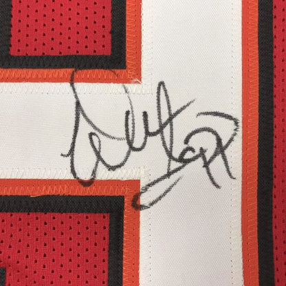 A black ink signature on a white mesh tampa bay football jersey with red and orange trim framed and autographed