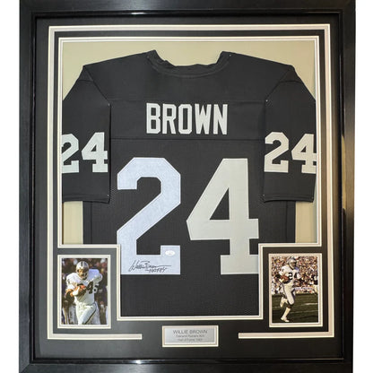 Signed black football jersey with white numbers, player photos, and a commemorative plaque