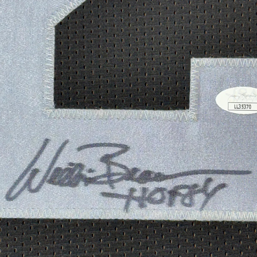 Black and white signed football jersey with autograph, photos, and commemorative plaque