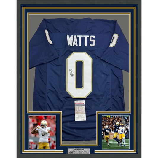 Back side of a framed autographed navy blue notre dame fighting irish football jersey with white number 0 and name watts