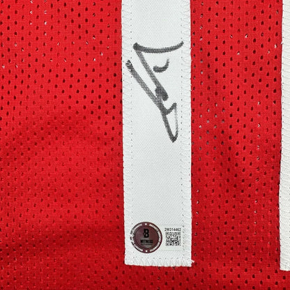 Red mesh sports jersey with black autograph and white authenticity patch in professionally framed display