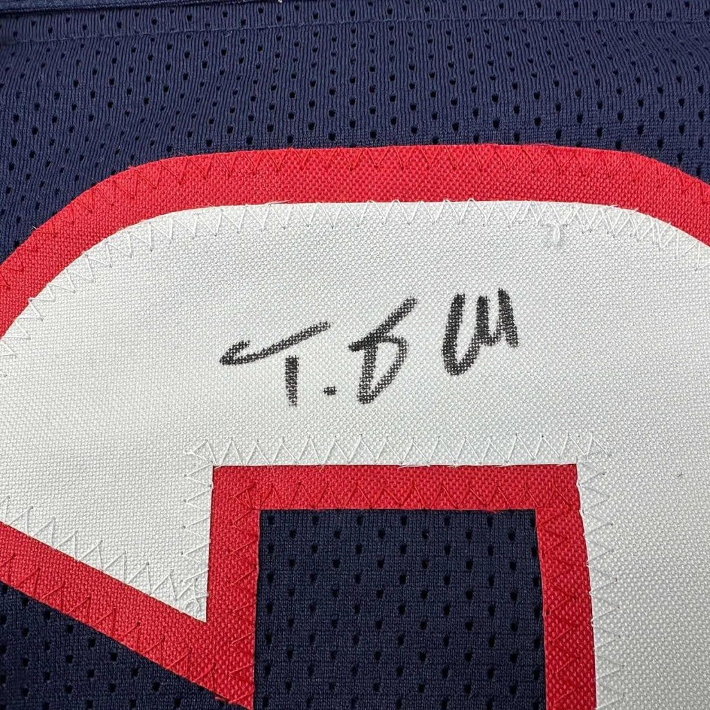Autographed dark blue Houston Texans jersey with red and white trim in a frame with player photos