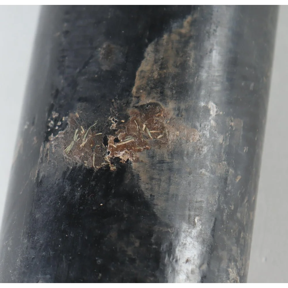 Damaged black pipe with corrosion, related to Noelvi Marte signed baseball bat product