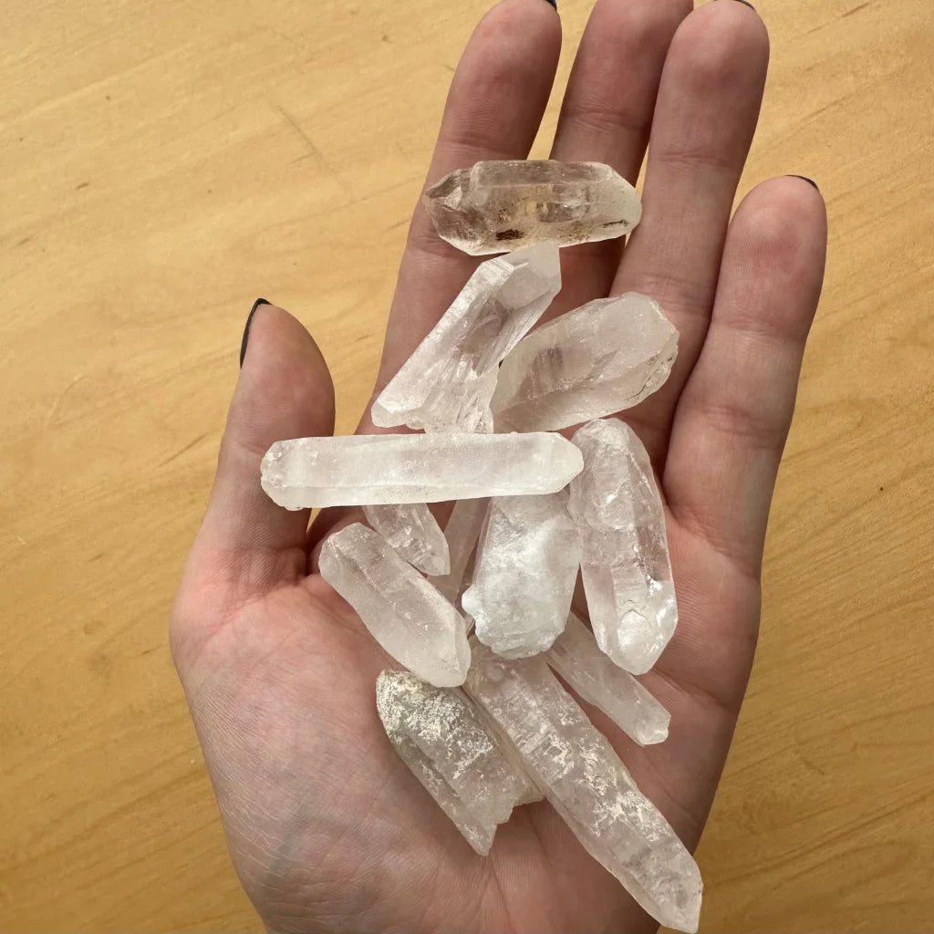 Hand holding genuine Brazilian quartz crystal point natural stone