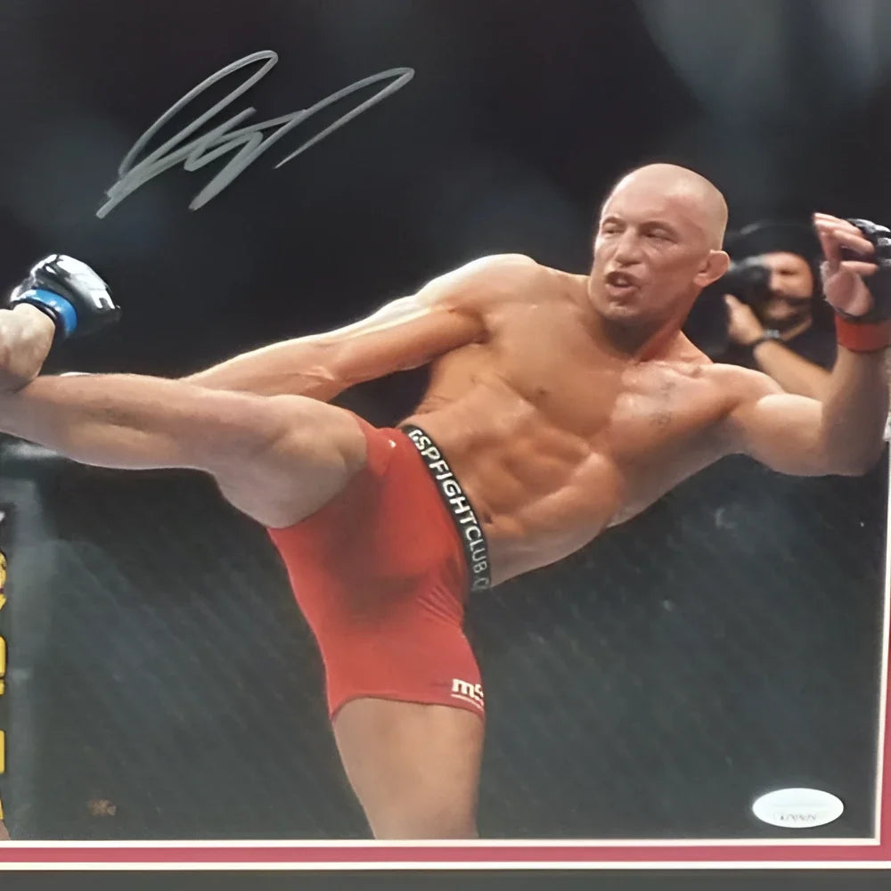A deluxe framed 11x14 photo of georges st pierre mid-kick signed in red shorts with blue and white gloves