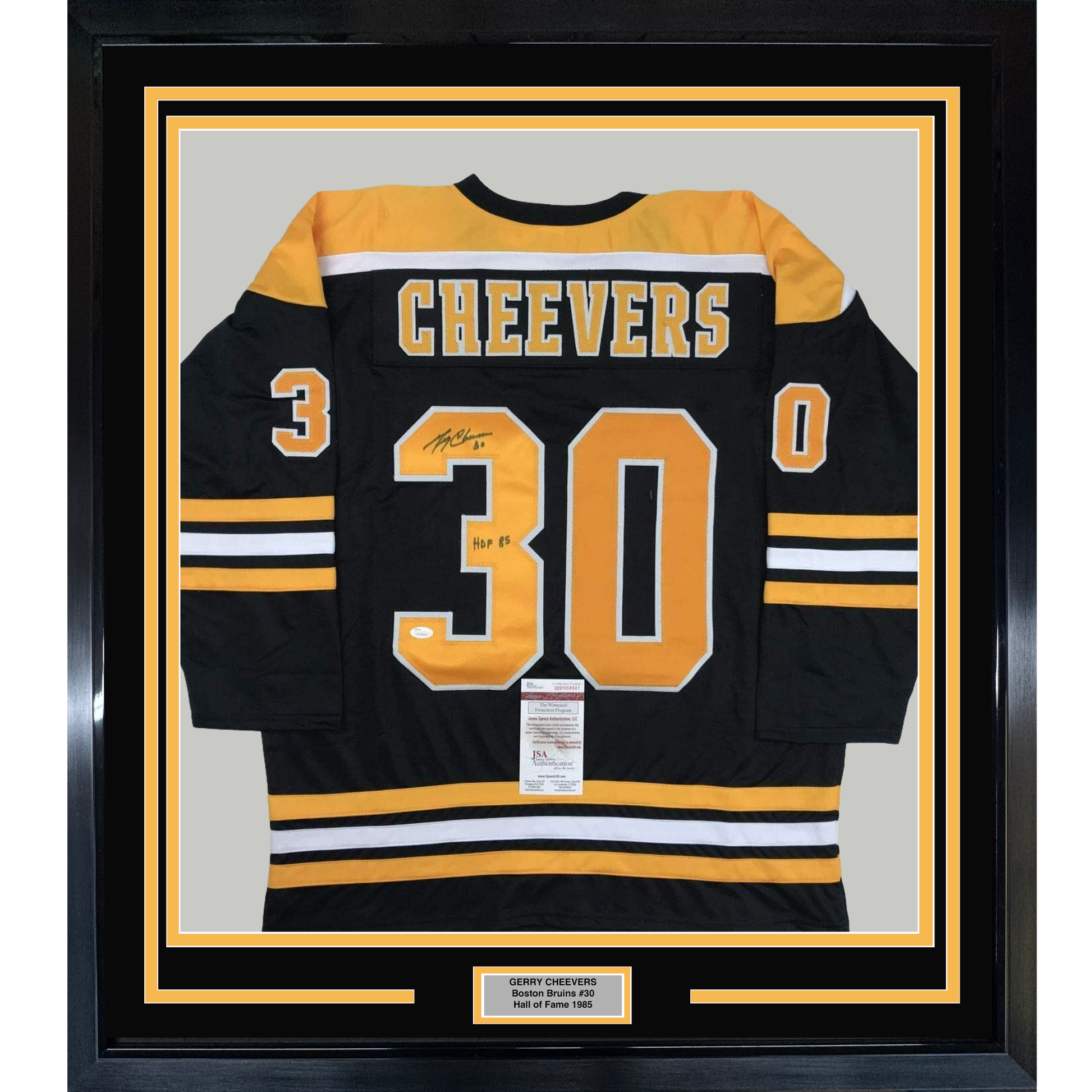 Black Boston Bruins hockey jersey number 30 with "CHEEVERS" across chest, framed behind glass with gold and black matting.