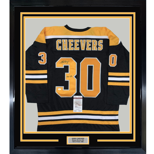 Black Boston Bruins hockey jersey number 30 with "CHEEVERS" across chest, framed behind glass with gold and black matting.