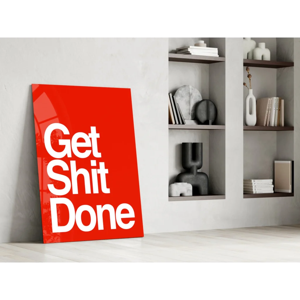 Vibrant red Get Shit Done glass wall art leaning against wall