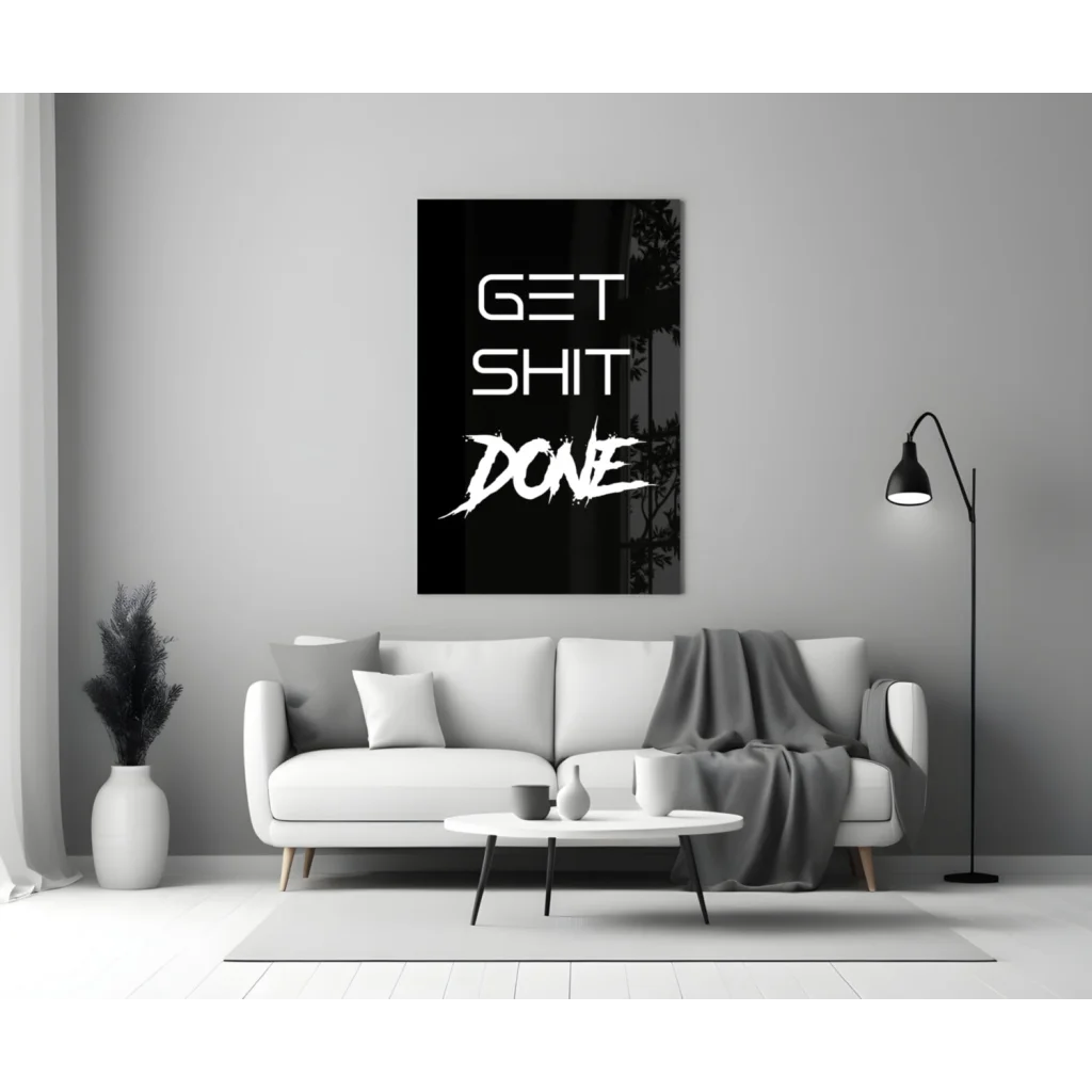 Bold get shit done glass wall art in white on black, hanging on gray wall