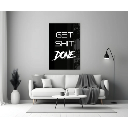Bold get shit done glass wall art in white on black, hanging on gray wall