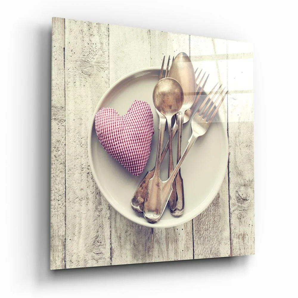 Gingham Heart Cushion in red white among vintage silverware on cream plate