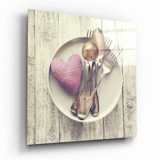 Gingham Heart Cushion in red white among vintage silverware on cream plate