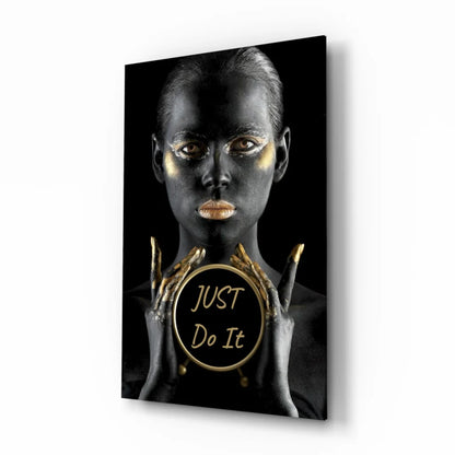 Golden woman with metallic makeup holding Just Do It emblem on glass wall art