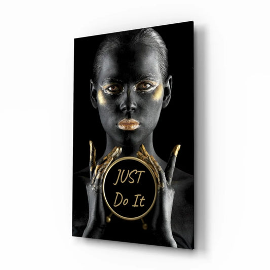 Golden woman with metallic makeup holding Just Do It emblem on glass wall art