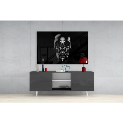 Glossy black skull wall art with metallic shine above gray console