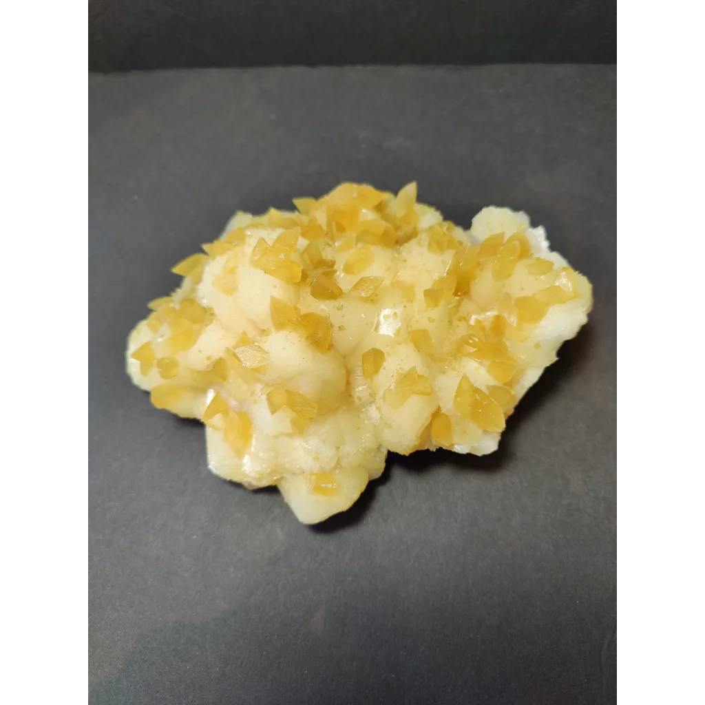 Golden calcite crystal cluster with translucent yellowish crystals in creamy base