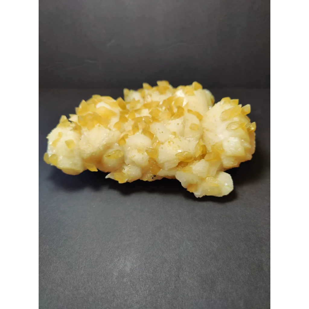 Golden calcite crystal cluster with translucent yellow crystals on white base