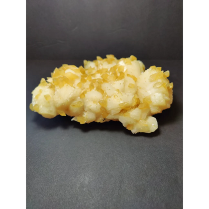 Golden calcite crystal cluster with translucent yellow crystals on white base