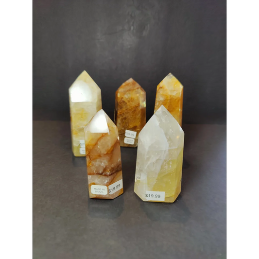 Four polished translucent yellow and orange golden healer quartz obelisk tower sculptures with natural inclusions