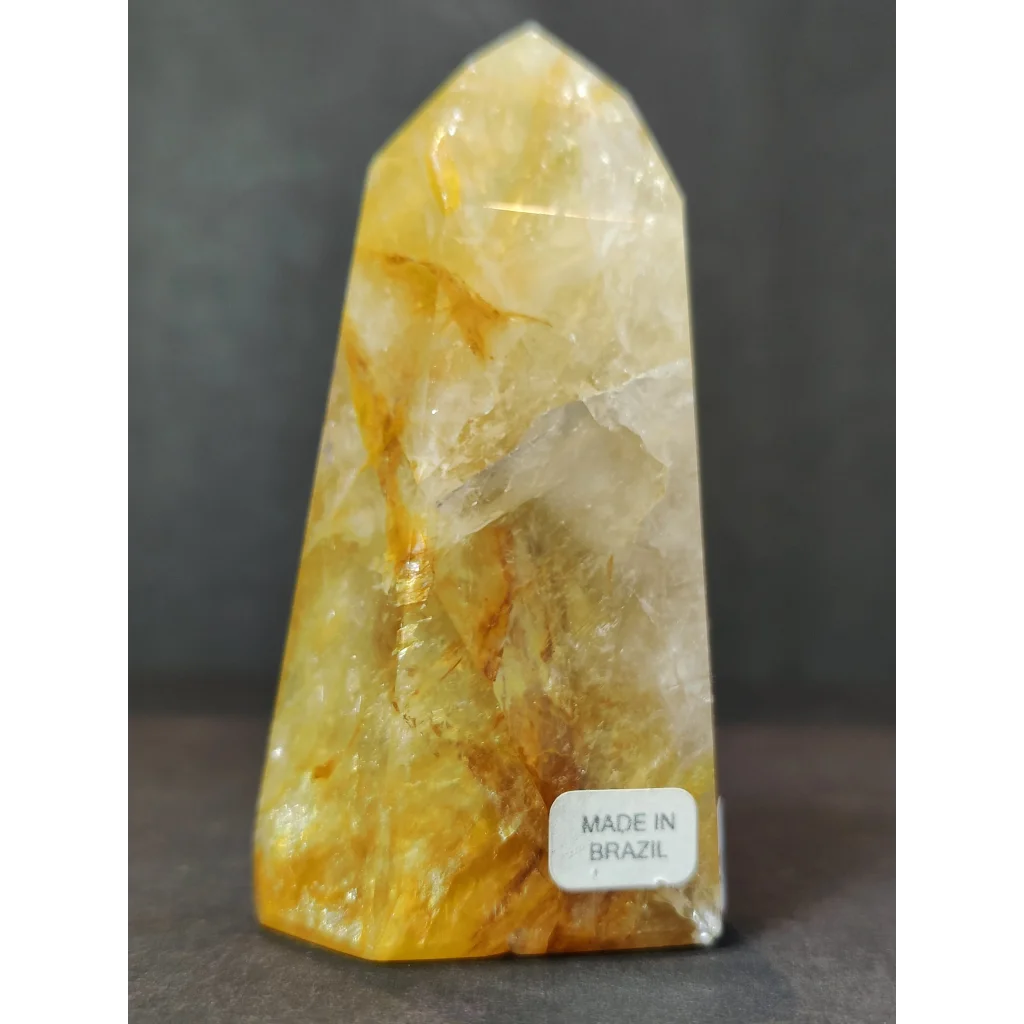 Polished golden healer obelisk tower sculpture made of translucent yellow and white fluorite with golden streaks