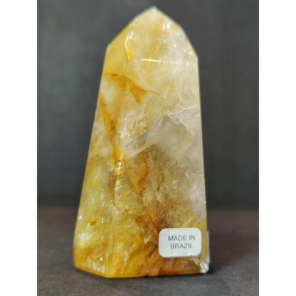 Polished golden healer obelisk tower sculpture made of translucent yellow and white fluorite with golden streaks