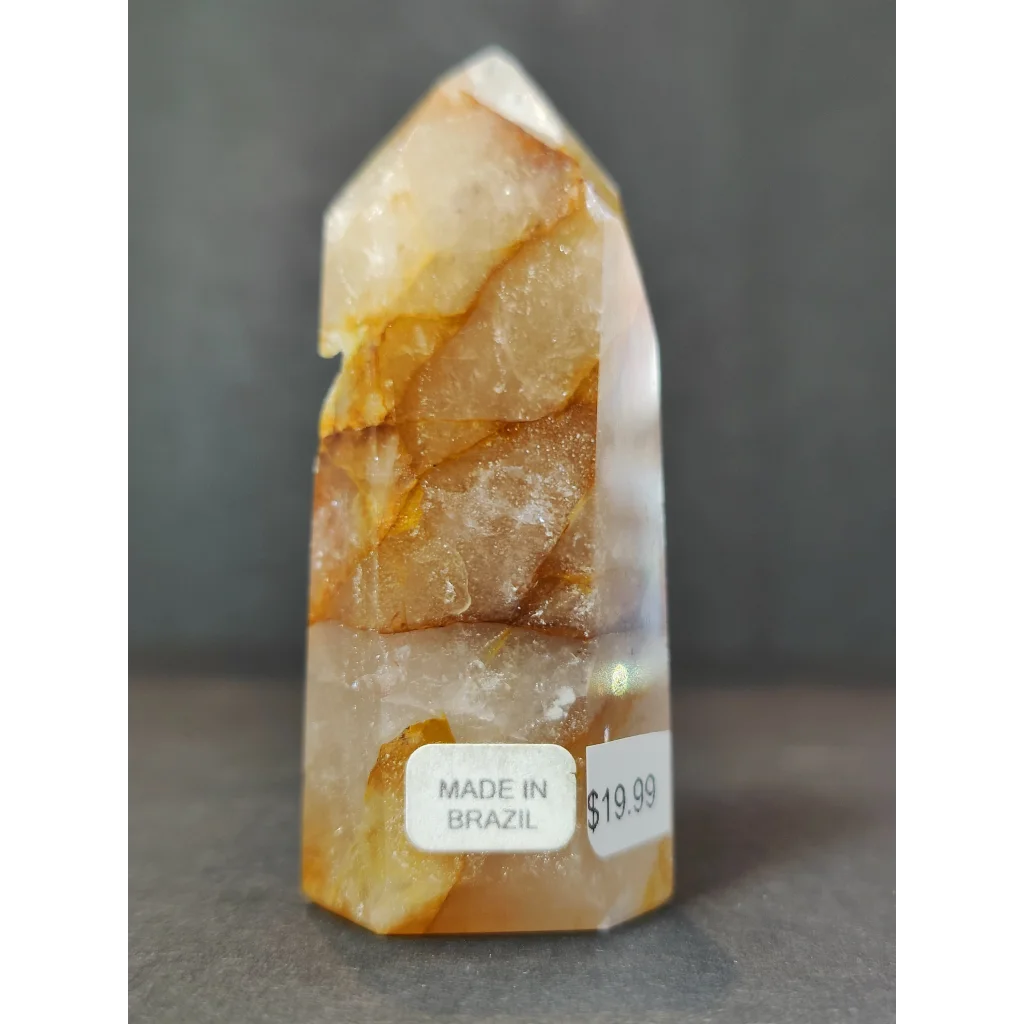 Translucent amber golden healer quartz polished obelisk tower sculpture with faceted top and natural mineral inclusions