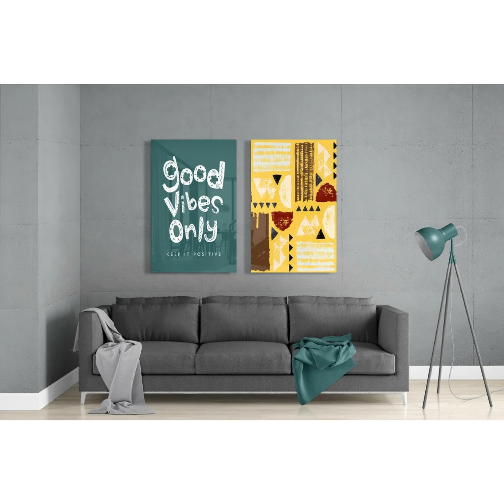 Gray sofa with throw and teal item near Good Vibes Only glass wall art